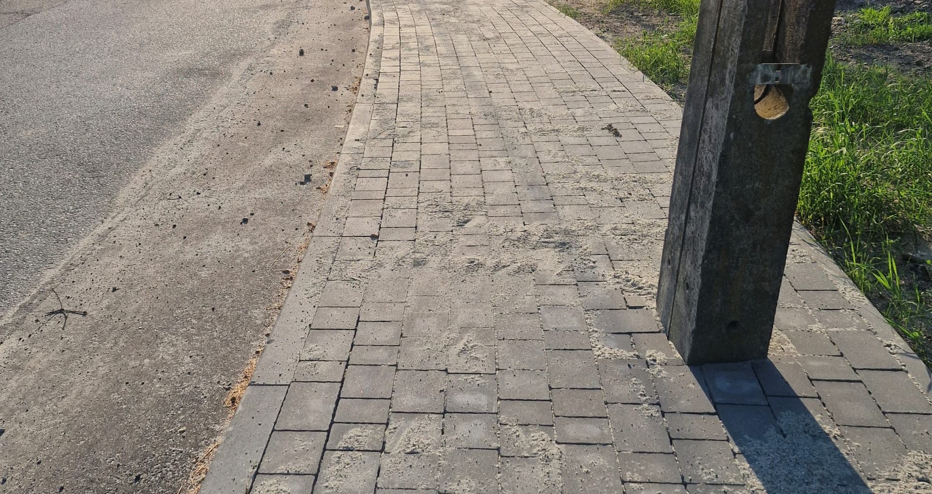 Absurd na ul. Dożynkowej? Mieszkańcy alarmują: słup stanął na środku nowego chodnika